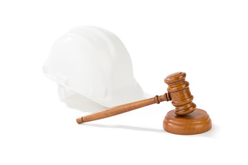 Labor law concept, wooden judge gavel and yellow helmet isolated on white background.  