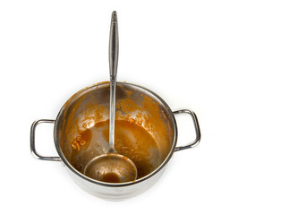Dirty kitchen pot with ladle from a tomato soup