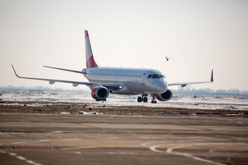 Naklejka premium Samolot pasażerski na lotnisku w zimowe popołudnie. samolot na peronie lotniska w zimie. Samolot na letnim pasku w zimie