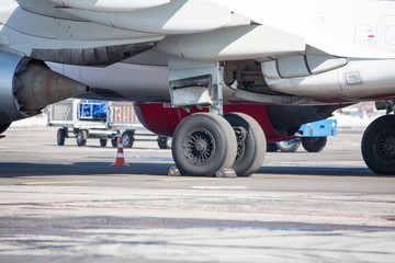 chassis airplane close-up in winter in snow. Close-up of chassis of passenger airliner in the snow on airport platform.