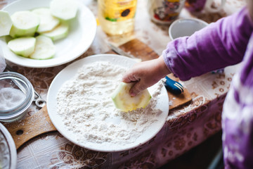 The child makes pancakes from zucchini. Concept of motor development in children.