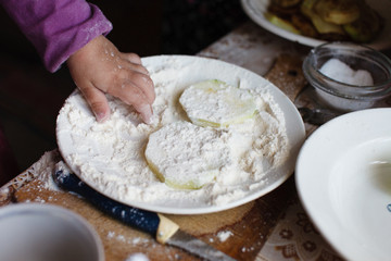 The child makes pancakes from zucchini. Concept of motor development in children.