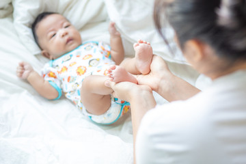 Mother making infant baby boy foot massage