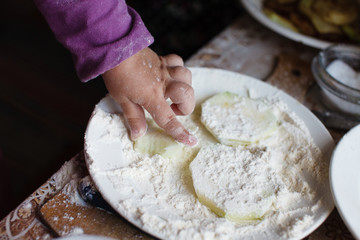 The child makes pancakes from zucchini. Concept of motor development in children.