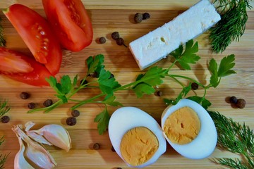 Tasty snack with tomato, garlic, feta, boiled egg and greens