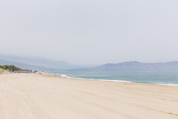 perspective sandy beach and sea coastline cloudy sky mountains in the background Rethymno Crete