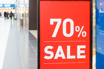 Large Sale 70 off letters on shopping mall wall pillar, bokeh shopping mall as background.Final sale.shopping, business fashion and advertisement concept.70 off sale banner at the clothing store