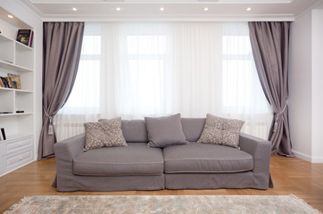 epmty minimalistic interior background, living room of modern apartment with big windows and sofa, daylight