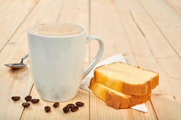 Coffee cup with pound cake on wooden table