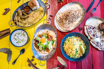 Set menu of delicious indian foods served on colorful table
