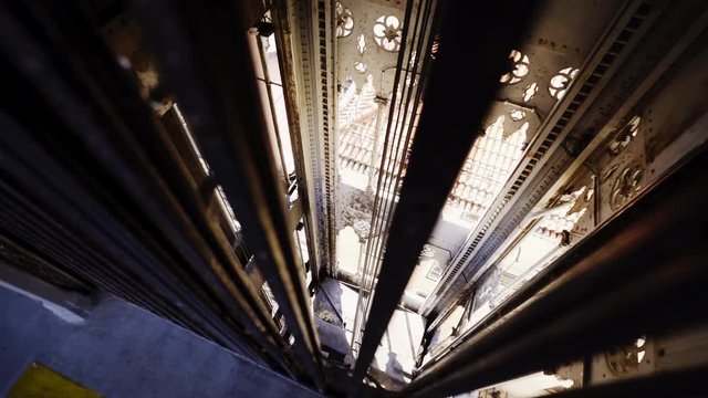 View through the bars Inside lift shaft of Santa Justa Lift in Lisbon in sunny day. Descending elevator cabin in shaft