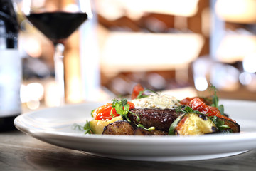 Entrecote steak with herb butter and grilled vegetables served with a glass of red wine.