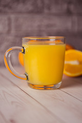 Glass of freshly squeezed orange juice standing on light background with a fresh oranges.  Healthy lifestyle concept