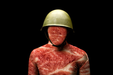 A man in a military helmet.  Texture of the meat on the body. Concept - soldier is just meat in the...