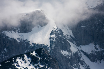 Fototapeta na wymiar Landscape with beautiful rocks and dramatic cloudy sky at snowy mountain