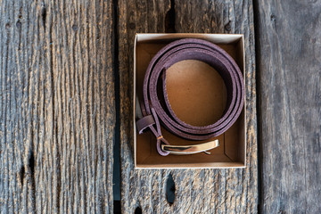 Leather belt hand crafts with solid brass buckle on wood table