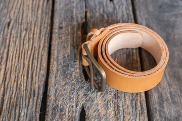 Leather belt hand crafts with solid brass buckle on wood table