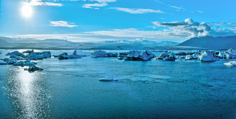 Panoramic view of Jokulsarlon glacier lake and Breidamerkurjokull glassier at the background facing to the sun.