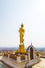 Golden buddhist statue on mountain in Nan