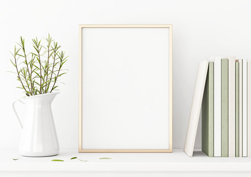 Vertical poster mockup with golden metal frame standing on table and decorated with jug, green plants and pile of books on empty white wall background. 3D rendering, illustration.