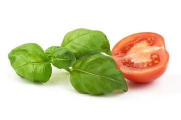 Sweet fresh basil leaves with half of tomato, close-up, isolated on white background