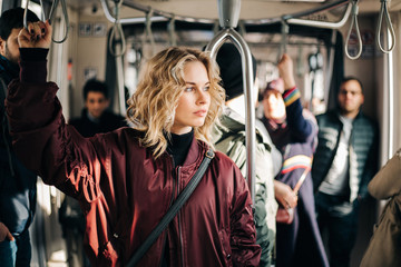 Image of curly blonde riding in bus. - obrazy, fototapety, plakaty