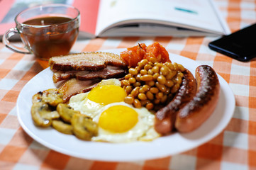 Traditional English or Irish breakfast: sausages, bacon, egg, mushrooms, tomatoes and toasts....