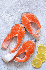 Fresh, raw salmon with lemon on a white concrete background. View from above.