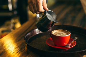 Fototapeta na wymiar pouring milk into cup of coffee