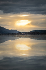 Fototapeta premium Sunset over lake Wörthersee with mountains Pyramidenkogel, Dobratsch and Karawanks