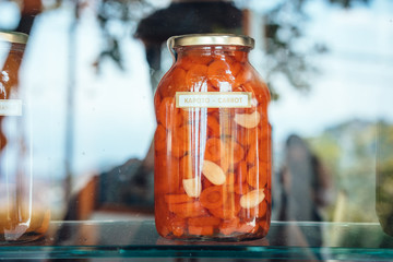 In the window is a closed two-liter can of marinated carrots.