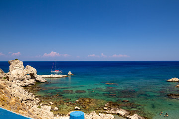 A sailboat stands near the coastal cliffs. The mediterranean.
