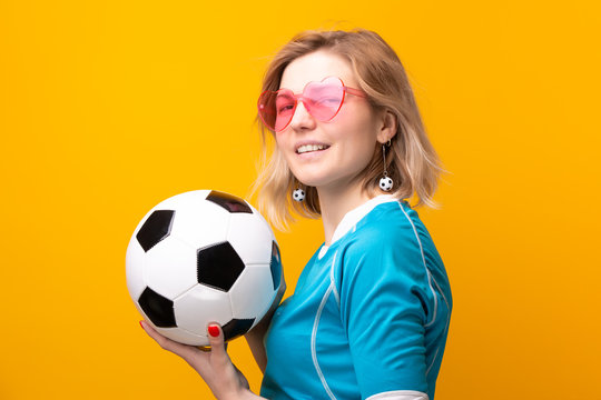 Image of blonde in pink glasses with soccer ball on orange background