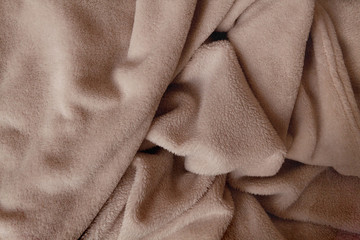 Crumpled soft hairy blanket in light brown color