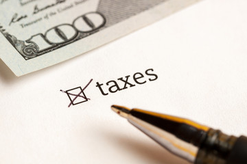 Fototapeta premium Checked checkbox with word taxes and dollars at background. questionnaire concept.