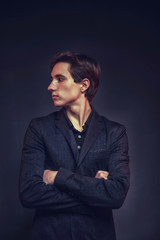 Obraz premium Portrait of an expressive, stylish, young man in a strict suit in orange tones with a smoky background
