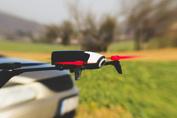 Flying drone overtake the car on the street