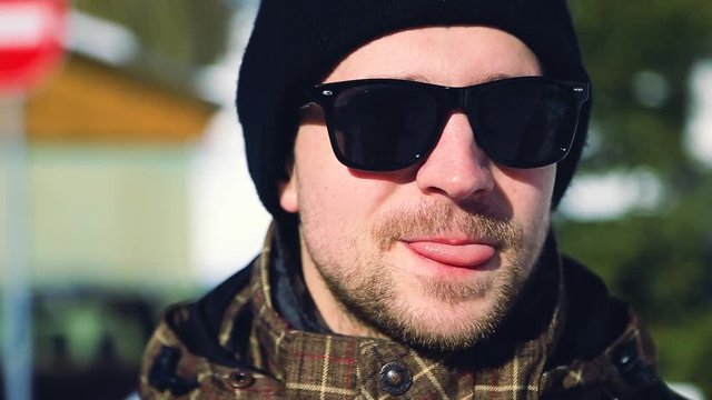 Close up face handsome stylish man in sunglasses looking at camera outdoors enjoy winter city snowy weather happy smiling emotional face cheerful joy funny joke young businessman freelancer portrait