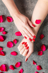 Young lady is showing her red manicure nails
