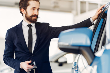 Man buying the car. Businessman in a car salon