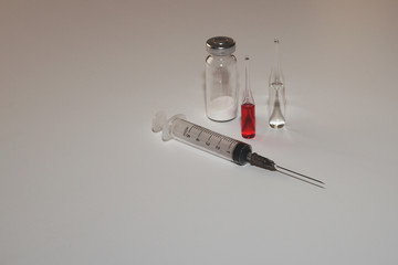 medical preparations in vials with a syringe on a white background