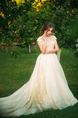 Charming bride with beautiful makeup and hairstyle posing for photographer