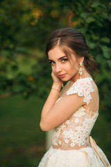 Naklejka premium Portrait of young bride in wedding dress. Happy bride in the park