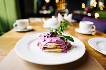 stack of pancakes with jam on white plate with ornate