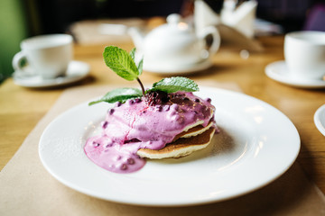 stack of pancakes with jam on white plate with ornate
