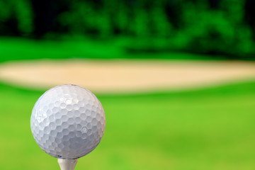 Close up photo of a golf ball in the golf course in a warm sunset light