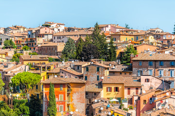 Fototapeta na wymiar Perugia, Italy Umbria cityscape with historic old medieval Etruscan buildings and rooftops of town village yellow orange colors in summer satellite dishes