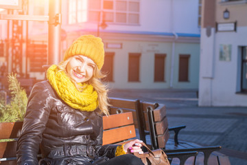 Portrait of attractive blonde hair woman weating yellow colors winter clothes and knitted scarf