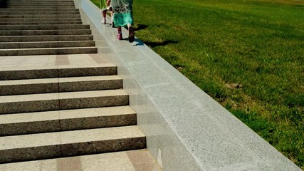 Two little sister walk on large granite staircase