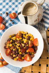 Salad of red beans, yellow corn, crackers. Picnic basket and a beautiful blue towel.